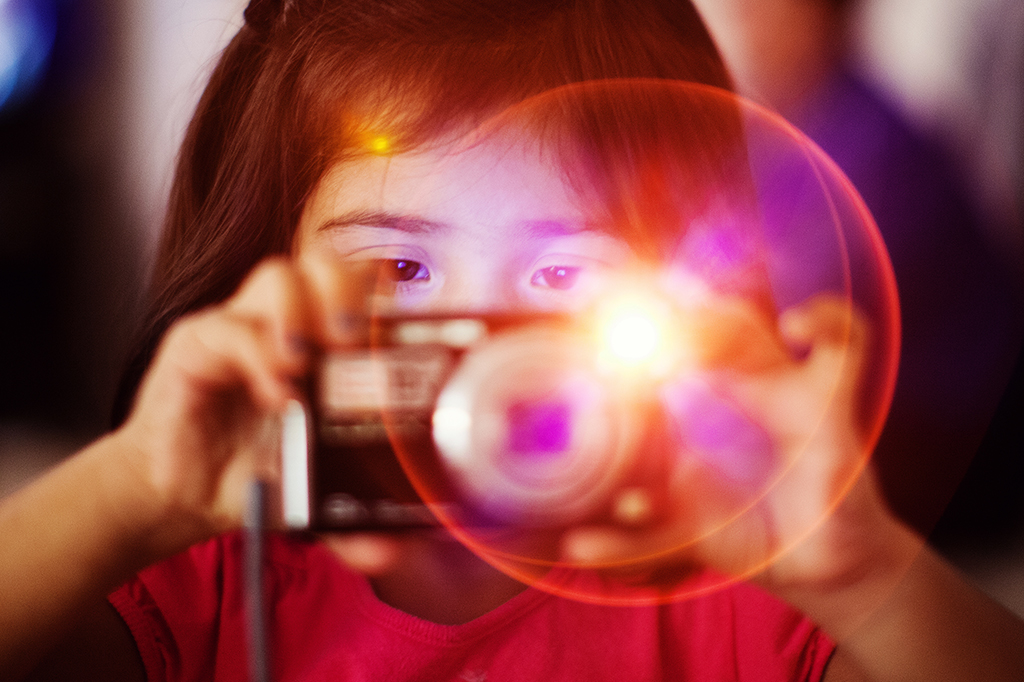 Uma criança tirando uma foto com flash.