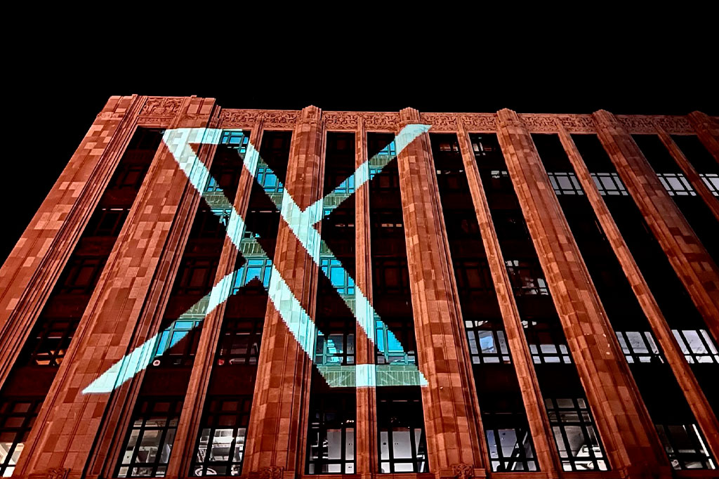 Logotipo de X, antigo Twitter, projetada na fachada de um edifício.