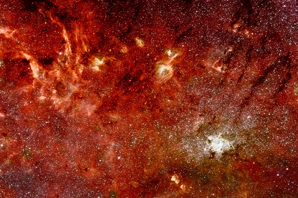 Visão infravermelha da Galáxia gerada por combinação da imagem nítida da câmera infravermelha próxima do Telescópio Espacial Hubble e do espectrômetro multi-objeto (NICMOS) com imagens coloridas de uma pesquisa anterior do telescópio espacial Spitzer feita com sua câmera de astronomia infravermelha (IRAC).