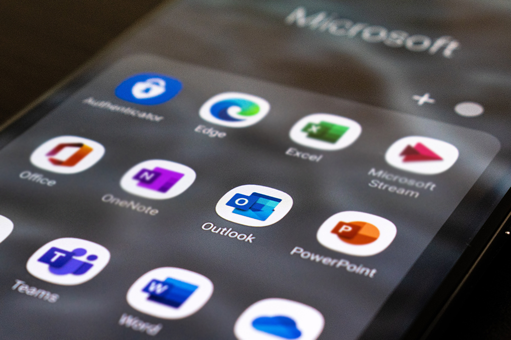 Imagem aproximada de uma tela de celular com os aplicativos da Microsoft com o foco no Outlook.