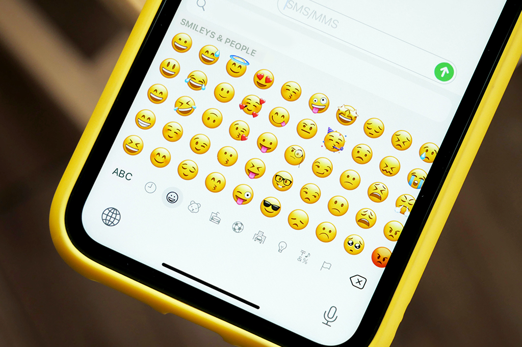 Imagem de um celular com o teclado de emojis aberto.