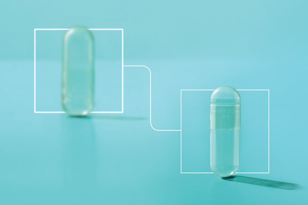 Foto de duas pílulas transparentes, a da esquerda desfocada e a da direita focada.