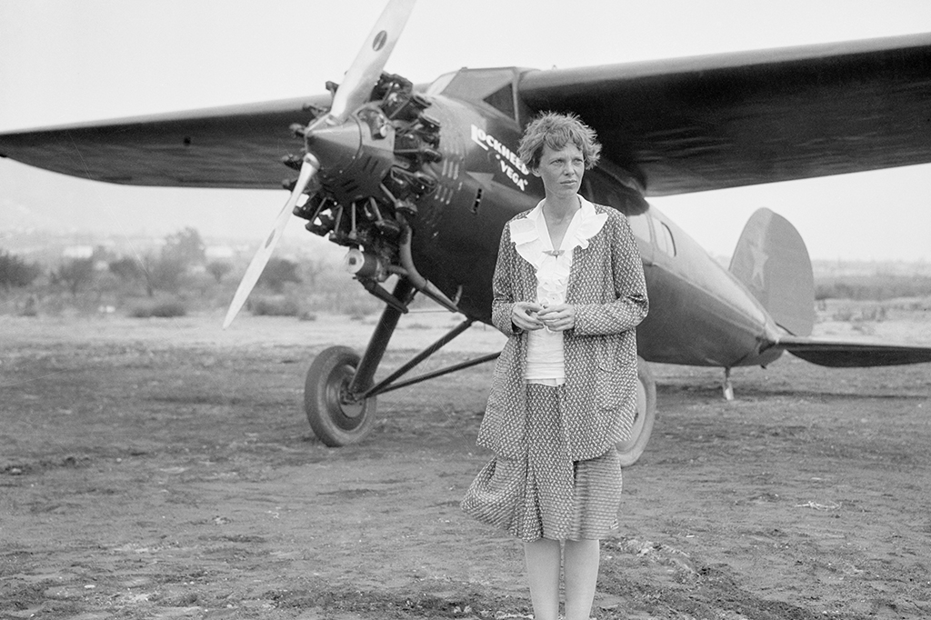 Amelia Earhart posando com seu avião