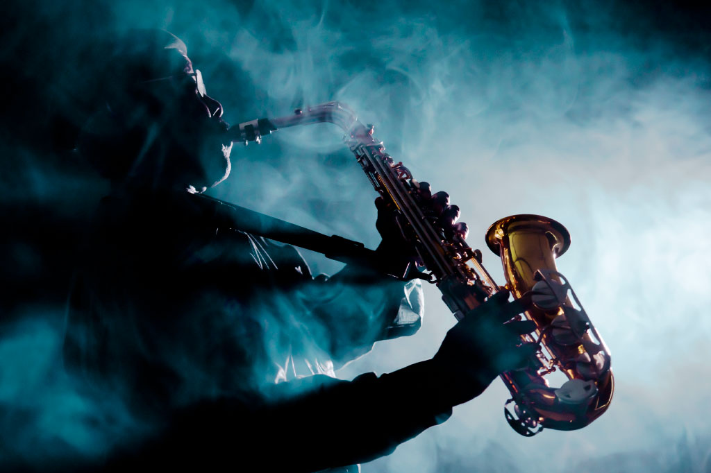 Homem negro tocando saxofone.