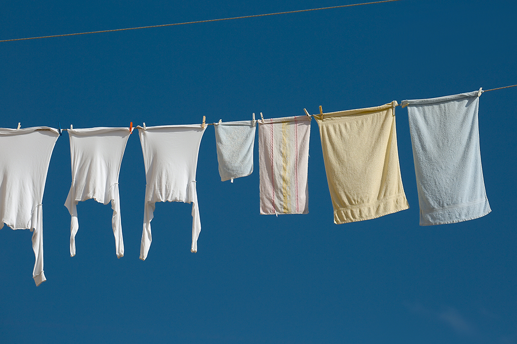 Roupas penduradas em varal em paisagem com céu azul