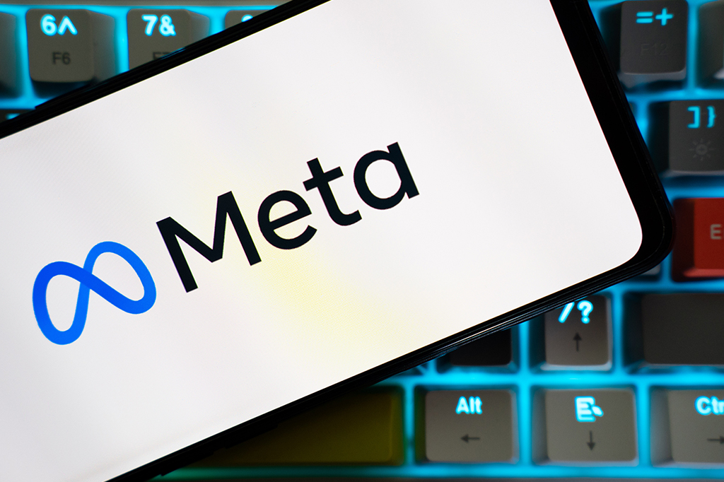 Tela de celular sobre teclado com o logo da empresa Meta.