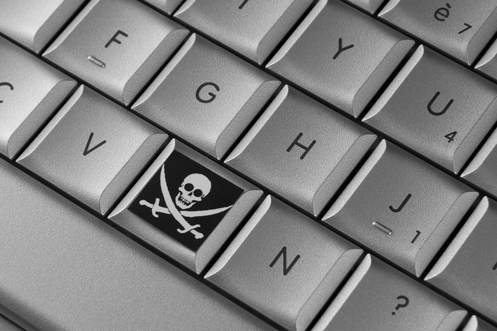 Fotografia de um teclado no qual uma das teclas é uma bandeira de pirataria.