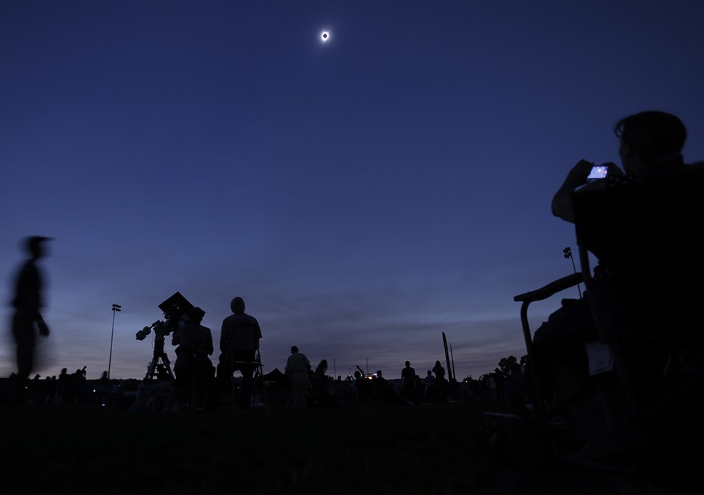 Espectadores assistindo o aparecimento de um eclipse solar total.