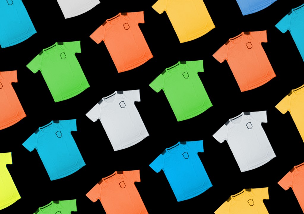 Diversas camisas de time de futebol coloridas dispostas sobre um fundo de cor preta.