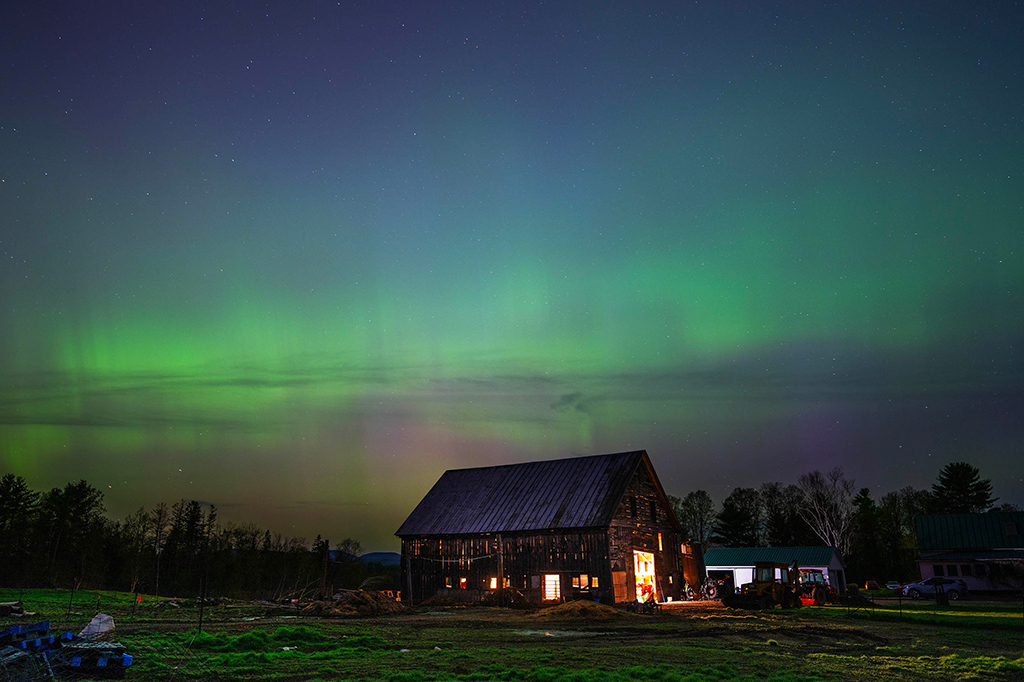 Aurora boreal no céu em um cenário de uma fazenda.