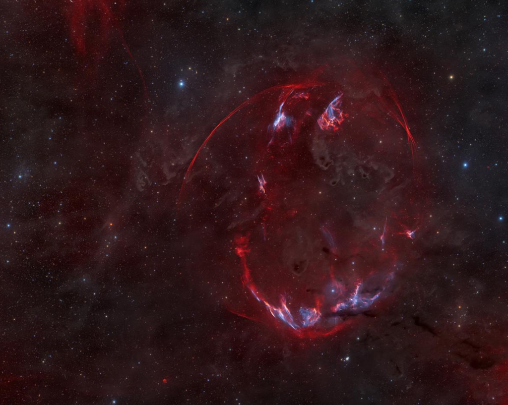 Remanescente de supernova (SNR) na constelação Auriga, que está situado atrás das nuvens escuras do complexo molecular Taurus-Auriga, que estão muito perto do Sistema Solar.
