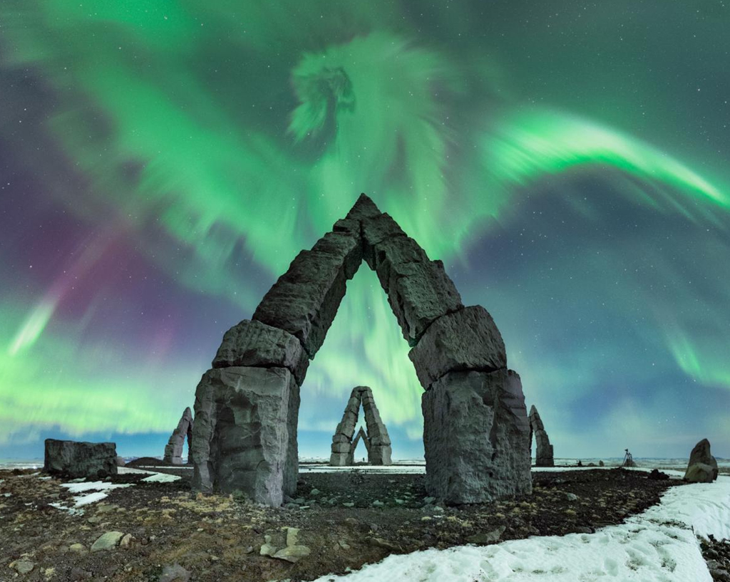 Aurora boreal, que parece um grande dragão sobre as pirâmides de pedra.