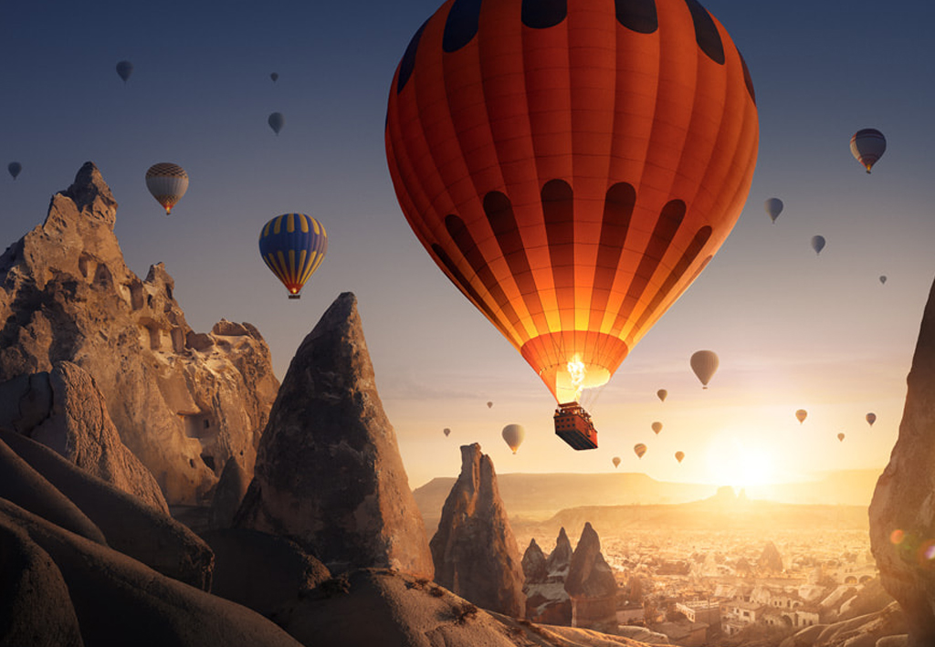 Balões de ar quente voando sobre paisagem da Capadócia.