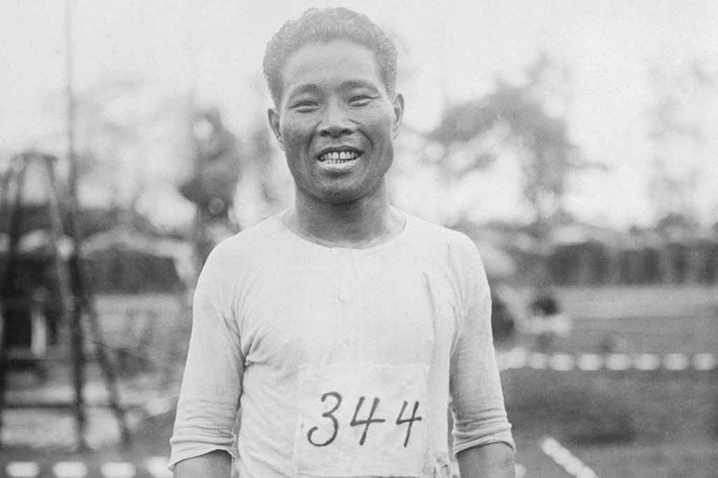 Um homem asiático. Ele está sorrindo para a foto.