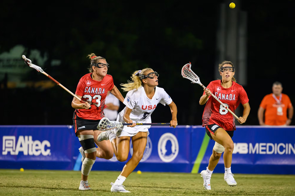 Mulheres em uma quadra de gramado praticando lacrosse.