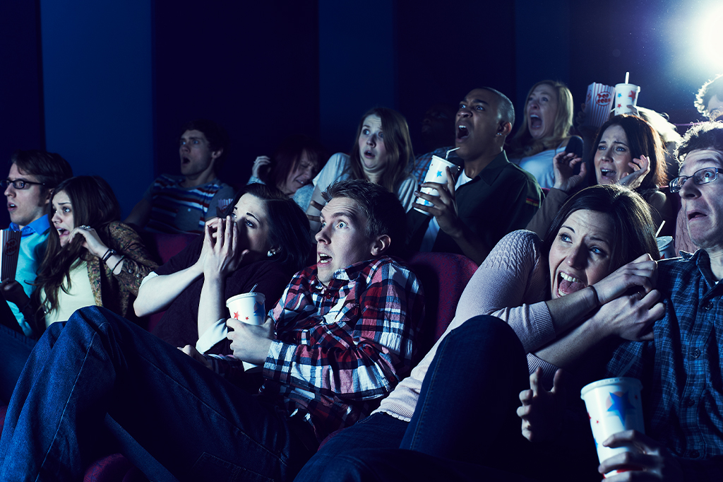 Foto de pessoas levando susto no cinema.