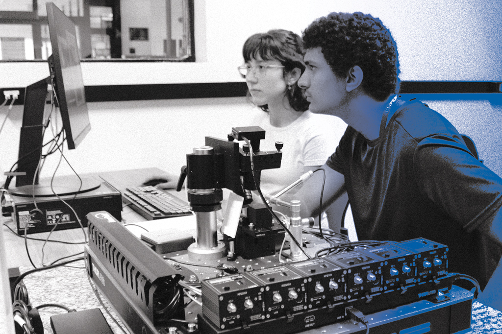SI_471_Fábrica_de_cérebros_1 Imagem de dois estudantes, em um laboratório, utilizando uma computador.