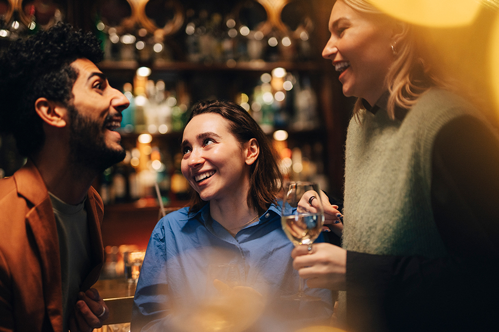 Fotografia de amigos conversando em um bar.