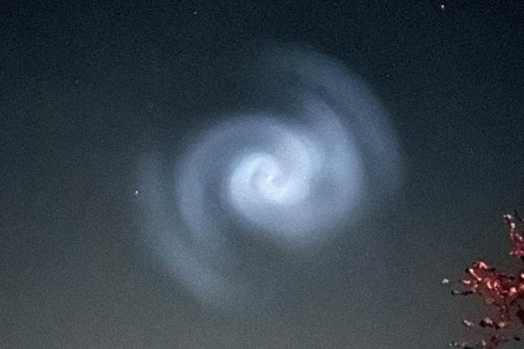 Luz azul em formato de espiral no ceu noturno da europa.