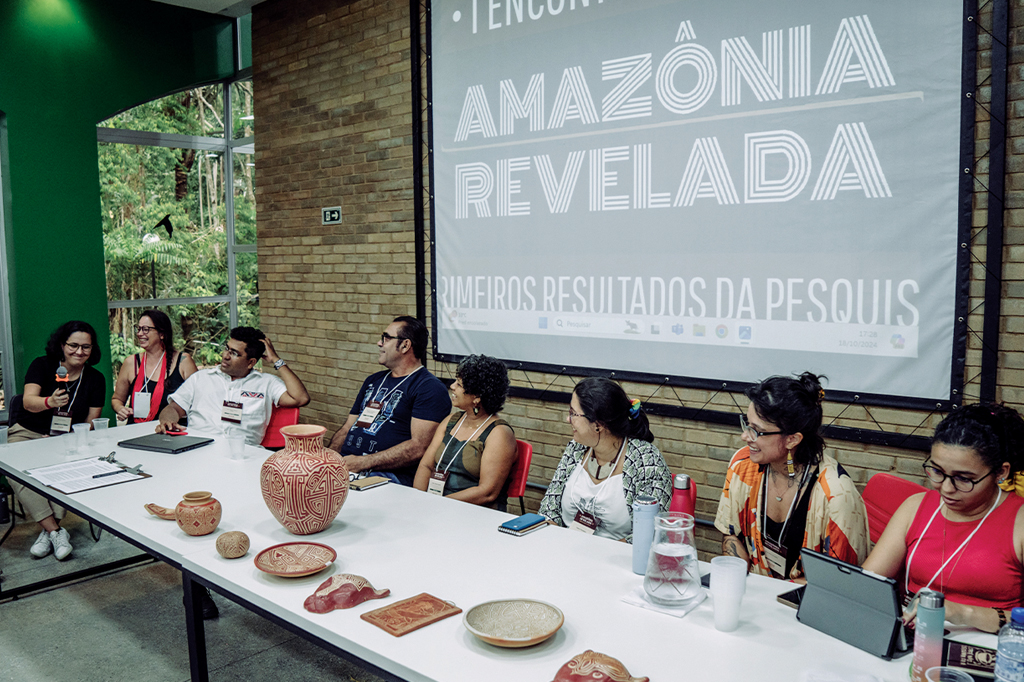 Imagem de um grupos de pessoas reunidas numa mesa.