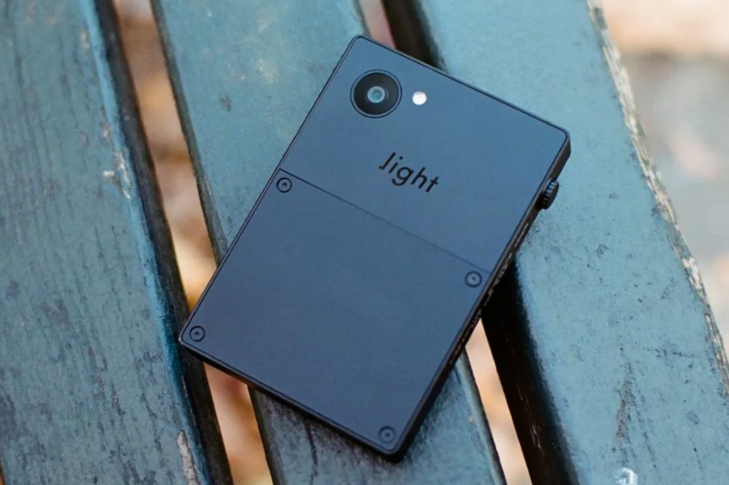 Imagem de um telefone celular preto em cima de um banco de jardim.