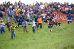 Fotografia dos participantes perseguindo o queijo na Cheese Rolling.
