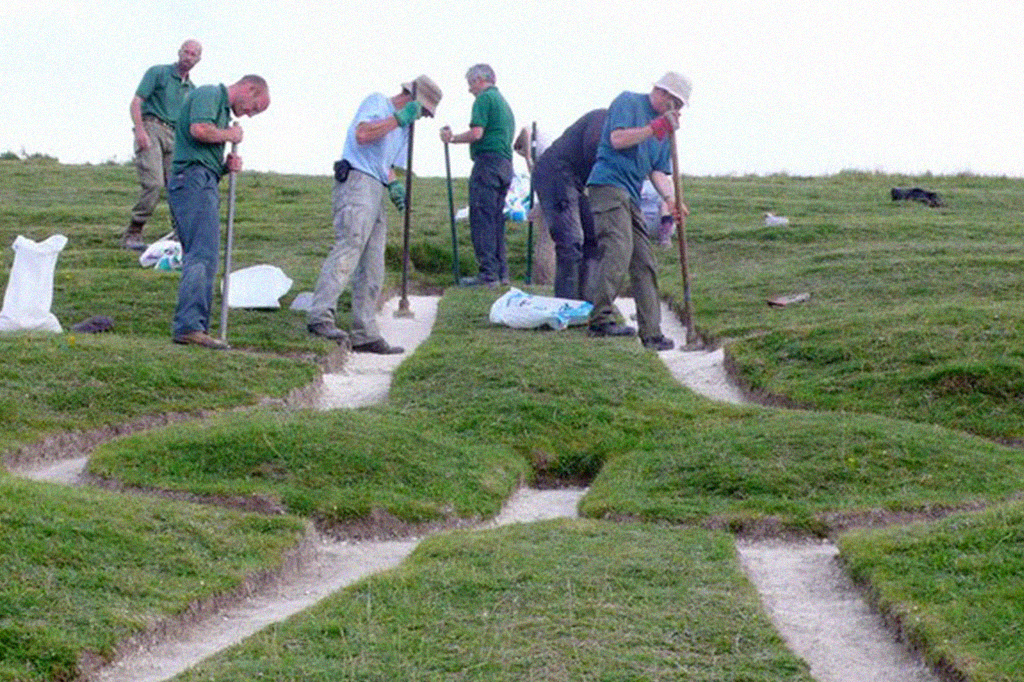 Fotografia de homens fazendo a restaura&ccedil;&atilde;o do Gigante de Cerne Abbas.
