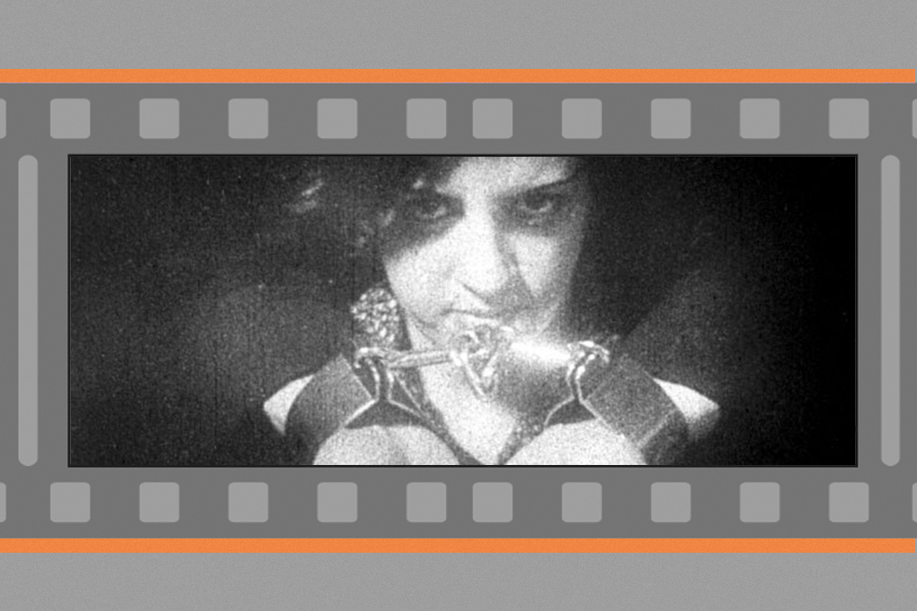 Imagem, em fundo cinza, de uma mulher de cabelos curtos e de olhar amea&ccedil;ador. Cena do filme Os Estranguladores (1908).