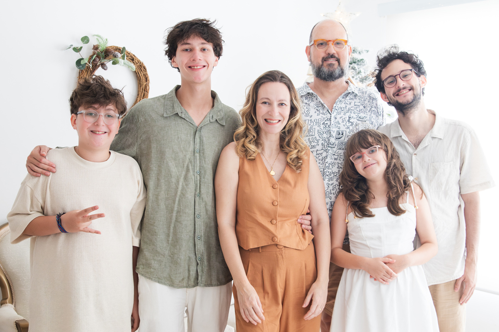 Imagem, em fundo branco, de uma fam&iacute;lia reunida. V&ecirc;-se o pai, a m&atilde;e e tr&ecirc;s filhos e uma filha. Todos est&atilde;o sorrindo.