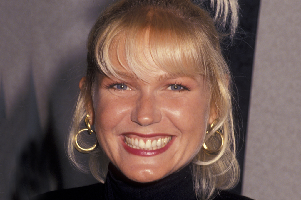 SI_479_Oráculo_Conexões_3 Imagem de uma mulher sorrindo, usando brincos e cabelos loiros.