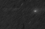 Imagem de um fundo espacial preto com listras brancas e um único ponto branco difuso. As listras são estrelas e o ponto é o cometa 3I/ATLAS.