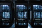 Imagem de uma sala escura com três supercomputadores de um data center.