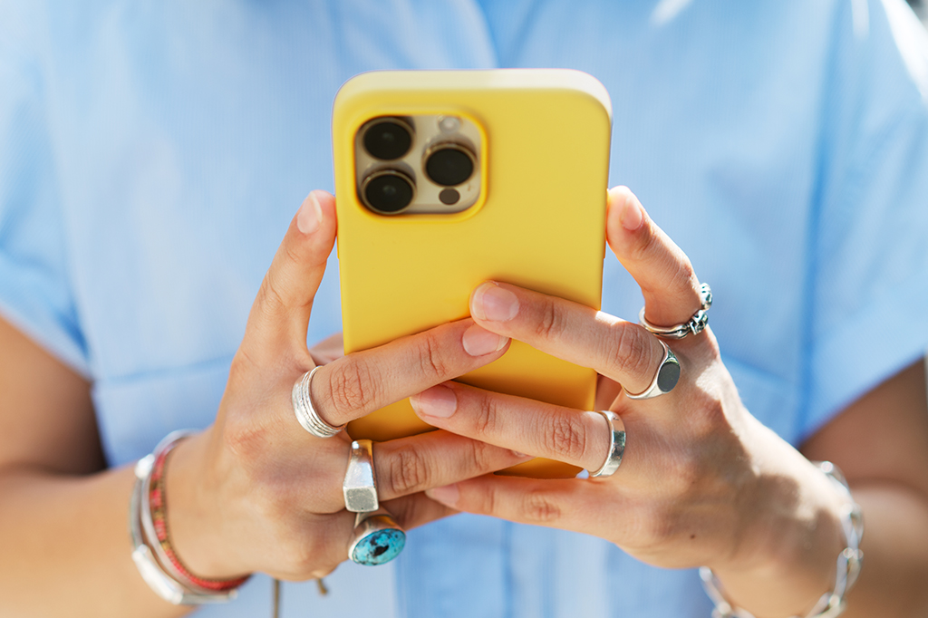 Fotografia de uma pessoa mexendo no celular.