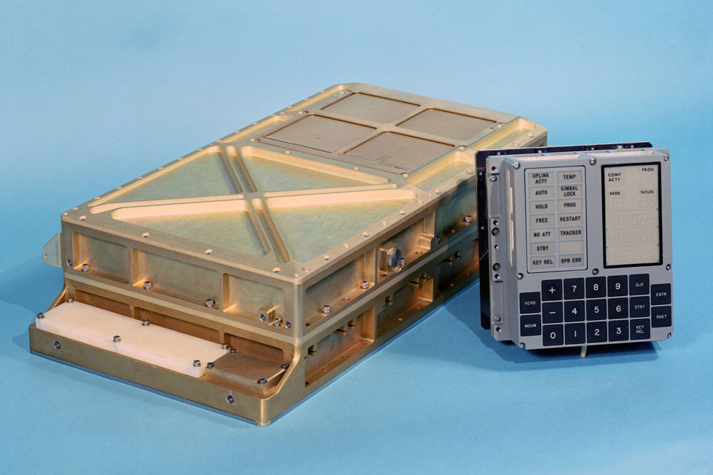 Imagem, em fundo azul, do computador de bordo da Apollo 11. Vê-se um hard disc e um painel de controle.