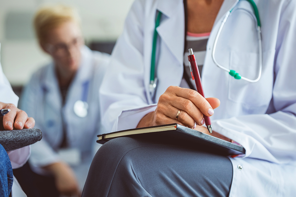 Fotografia de estudantes de medicina com cadernos para fazer anotações.