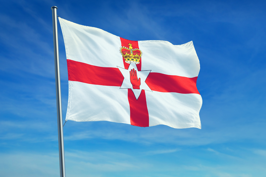 Imagem da bandeira da Irlanda do Norte tremulando ao vento.