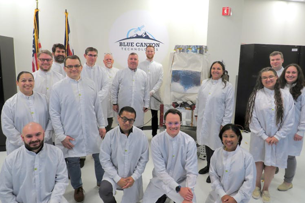 Fotografia dos integrantes da equipe Pandora SmallSat com o sat&eacute;lite conclu&iacute;do na sala limpa da Blue Canyon Technologies em Boulder, Colorado, antes de o Pandora ser enviado para a Calif&oacute;rnia para integra&ccedil;&atilde;o ao foguete Falcon 9 da SpaceX.