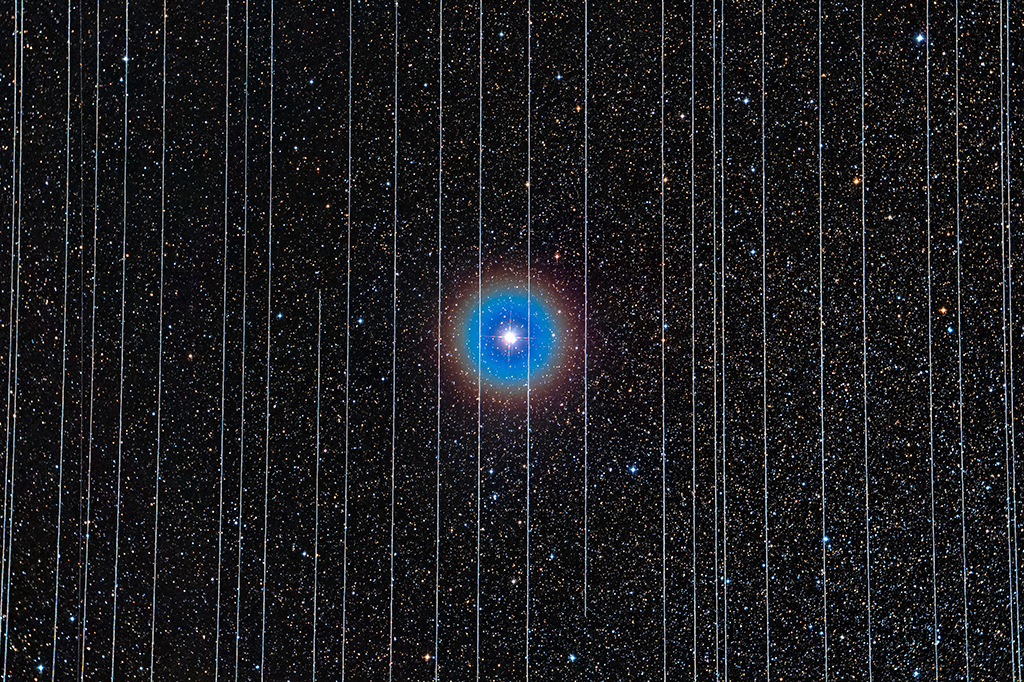 A imagem de fundo mostra a estrela dupla Albireo, na constelação de Cisne, e foi capturada em 26 de dezembro de 2019. Duas das dez exposições de 2,5 minutos registraram satélites Starlink se movendo pelo campo de visão.