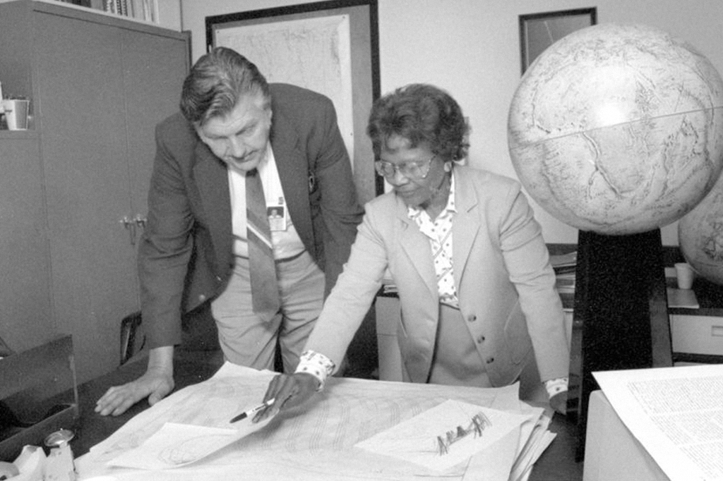 Imagem mostrando Gladys West e Sam Smith olhando dados do sistema de posicionamento global.