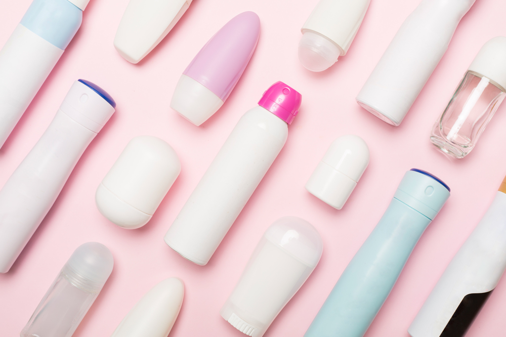 Imagem, em fundo rosa, de diversas embalagens de desodorantes.