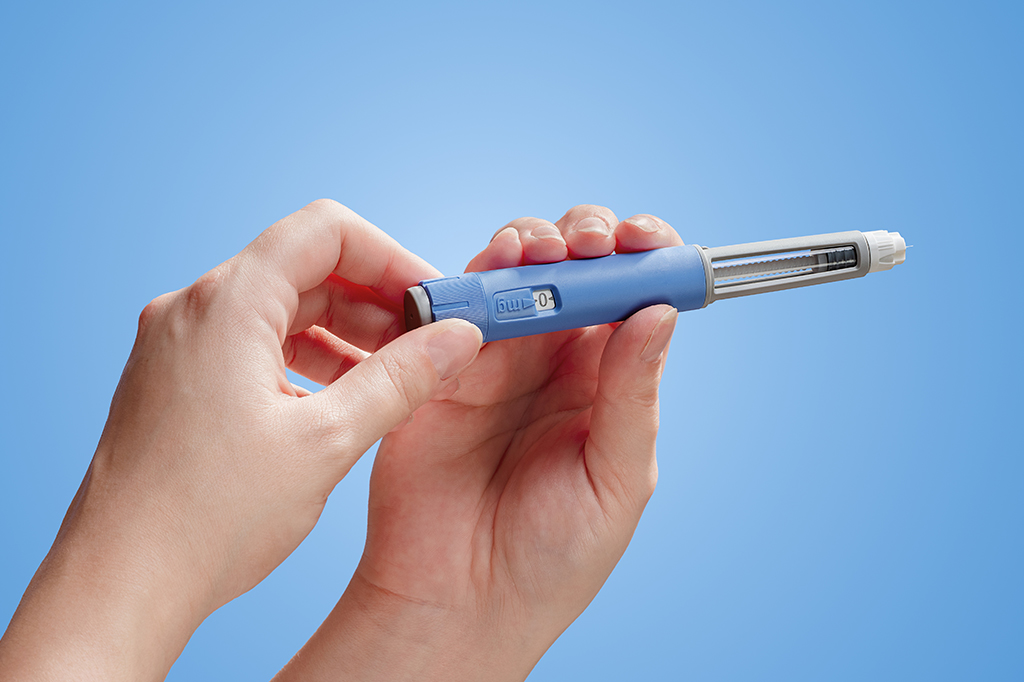 Fotografia da mão de uma mulher que segurando uma caneta de injeção da semaglutida.