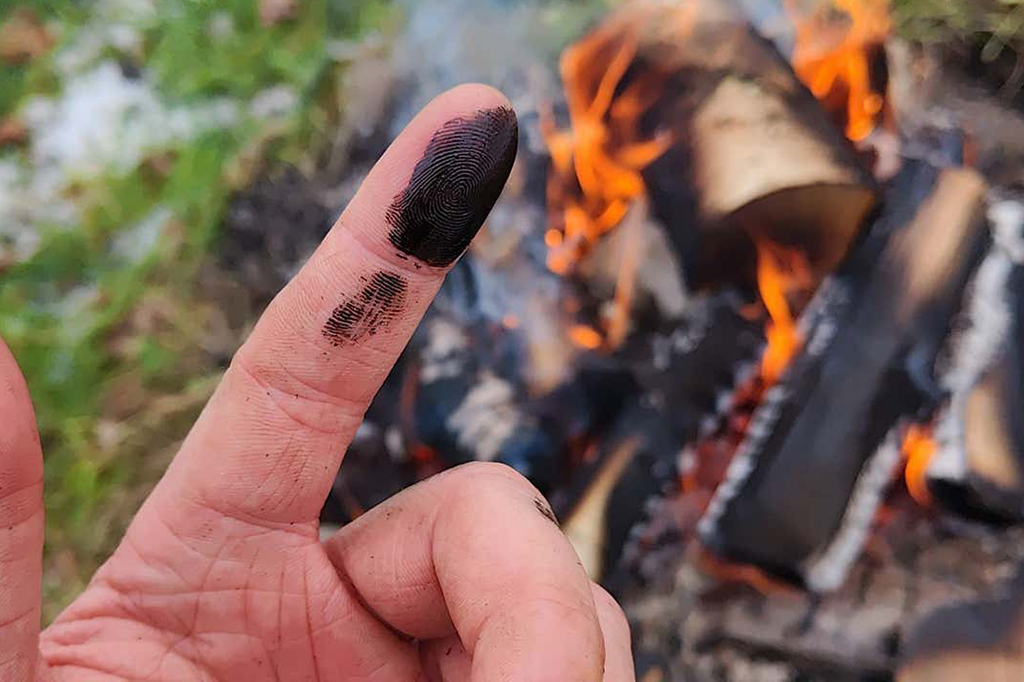 Fotografia de um dedo com carvão.
