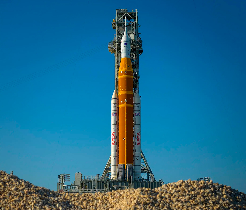 Fotografia do foguete Artemis II Space Launch System (SLS) da NASA e a espa&ccedil;onave Orion s&atilde;o vistos no topo de uma plataforma de lan&ccedil;amento m&oacute;vel no Complexo de Lan&ccedil;amento 39B.
