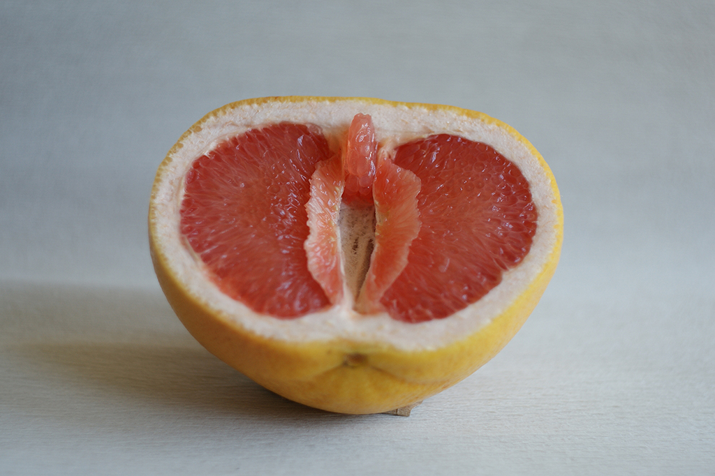 Símbolo da vulva, clitóris e lábios vaginais. A toranja tem a forma de uma vulva (vagina), com o clitóris e os lábios. Conceito de genitália feminina.