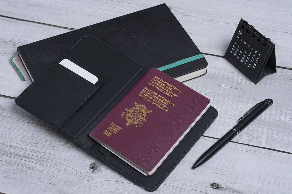Imagem de um passaporte sobre a mesa. Ao lado, vê-se uma caneta, um calendário e uma caderneta.