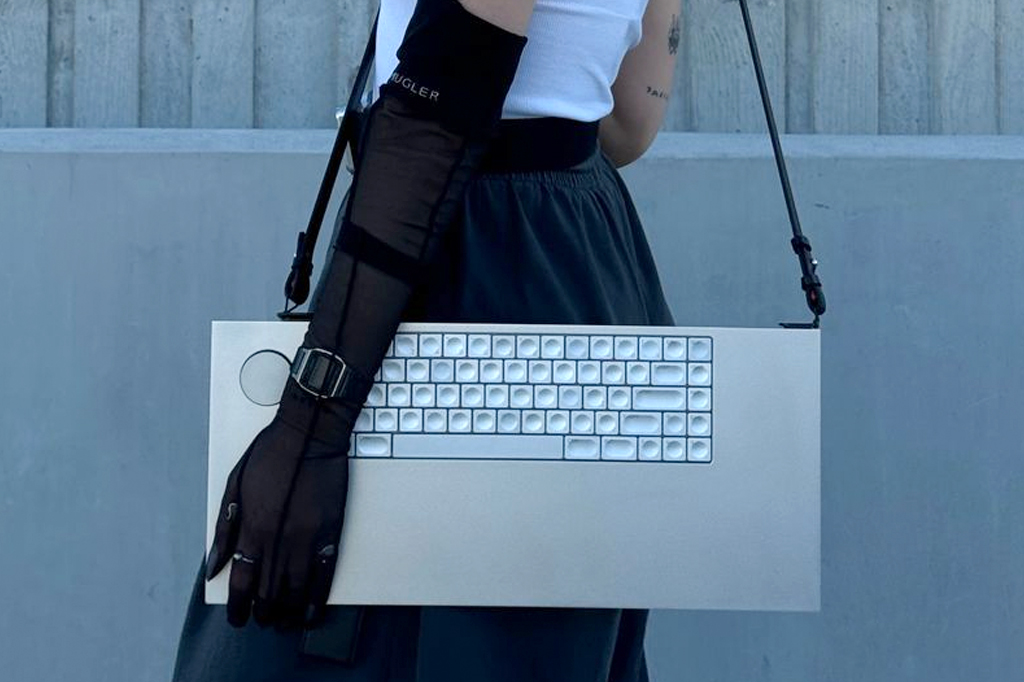 Imagem de uma mulher carregando um teclado com al&ccedil;as de bolsa.