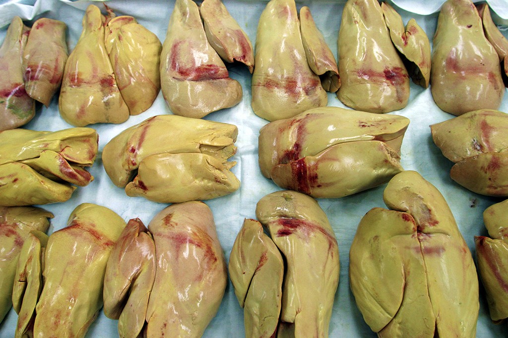 F&iacute;gados de ganso ou pato, de cor amarelada e com manchas avermelhadas de sangue, dispostos sobre um tecido branco