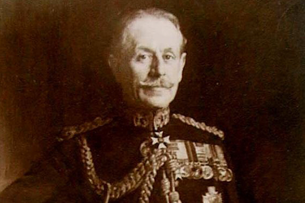 Retrato de um homem branco de meia-idade, com bigode e cabelo penteado para trás, vestindo um uniforme militar escuro com ombreiras trançadas douradas e várias medalhas no peito, incluindo uma cruz de ferro. Ele olha diretamente para frente com uma expressão séria.